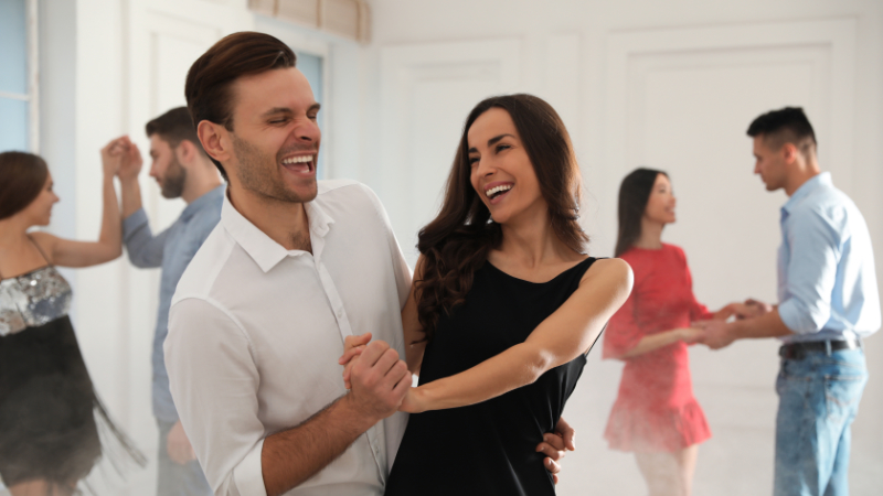 Lovely young couple dancing together at party Health benefits of dance